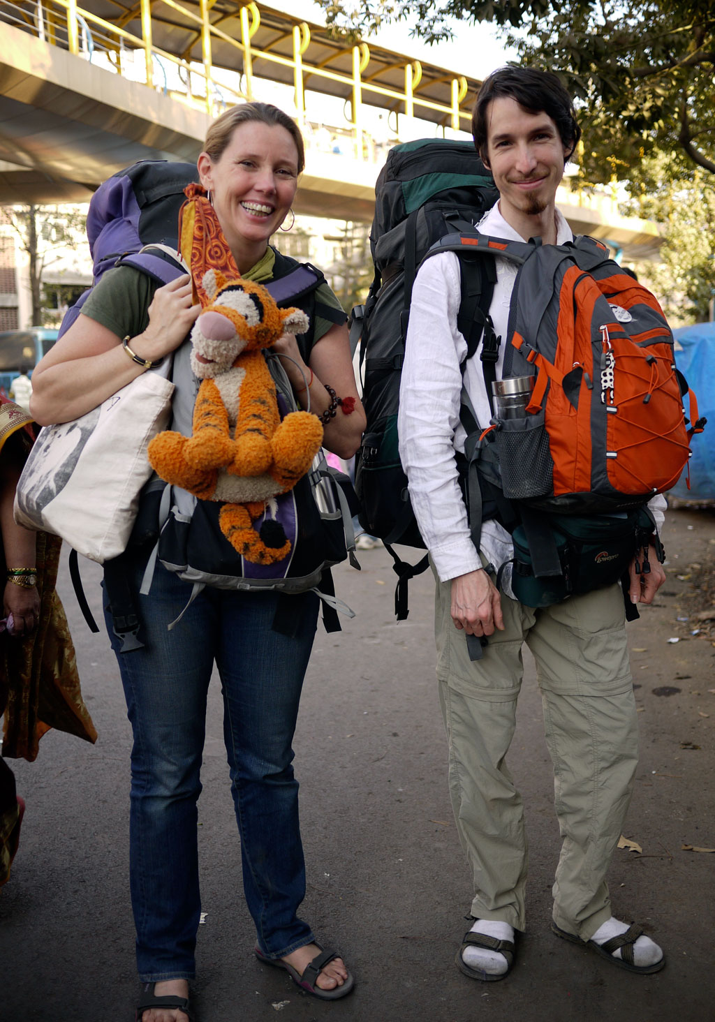 Catherine Cadden & Jesse Wiens Chu wearing backpacks on the road